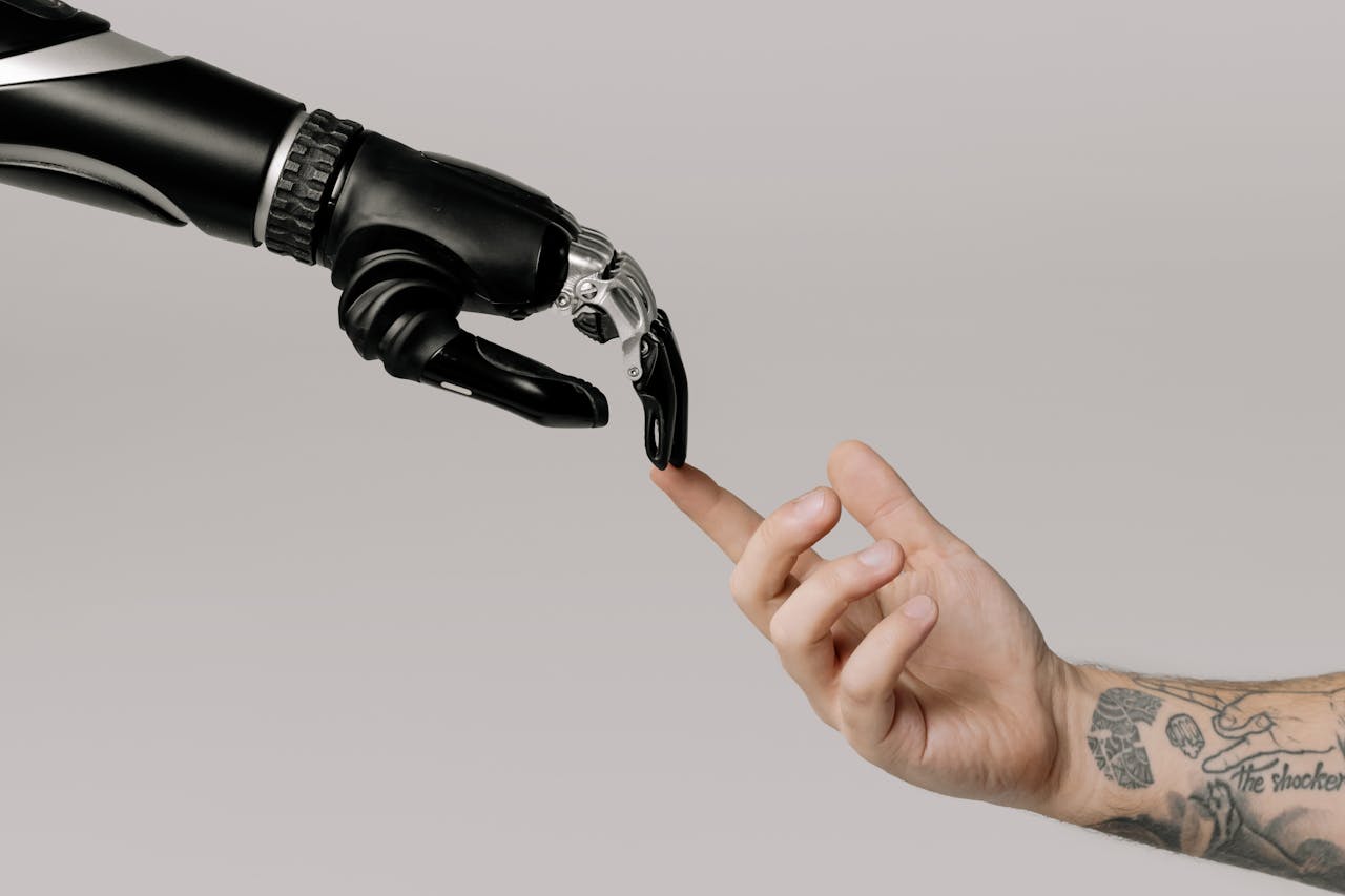 The Art of Drawing Readers In: Your attractive post title goes here A human hand with tattoos reaching out to a robotic hand on a white background.